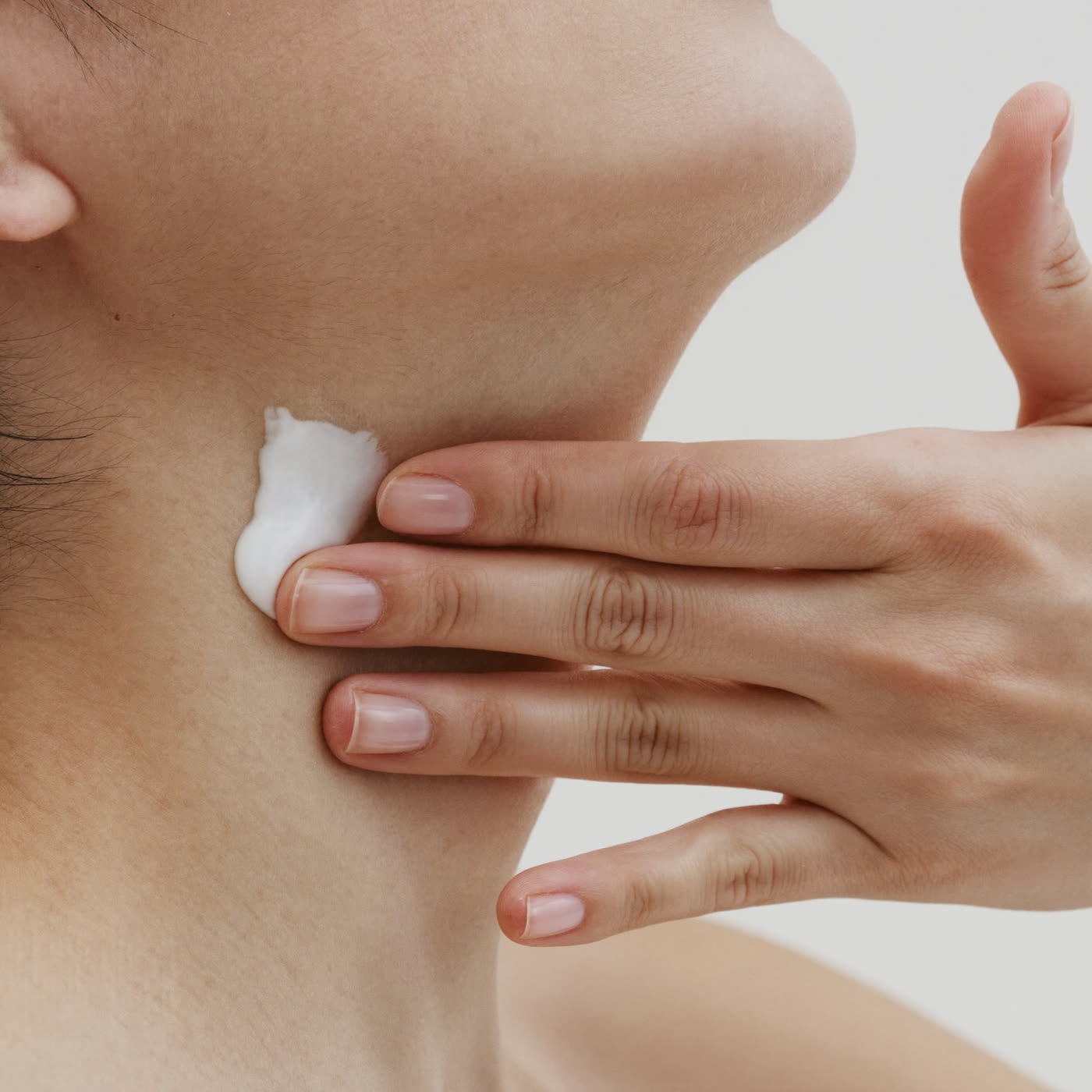 Applying the cream upward along the neck